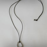 Momentum Necklace by Enso Design Lab, featuring a unique, fluid-inspired pendant in silver color. The necklace is laid flat with the leather cord visible.
