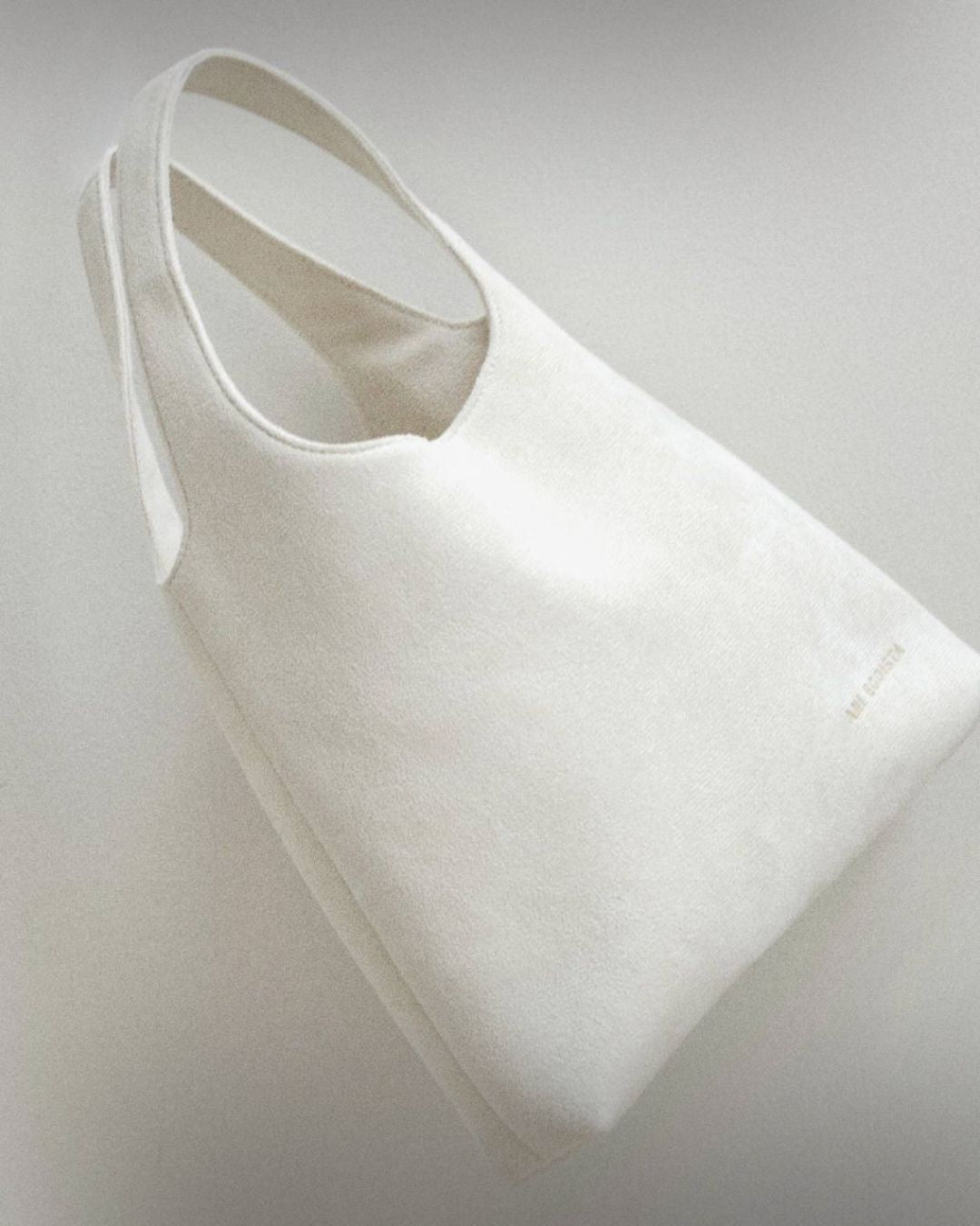 White reusable bag by Enso Design Lab, designed by Ani Han. The bag emphasizes sustainability and minimalist design, perfect for everyday use.