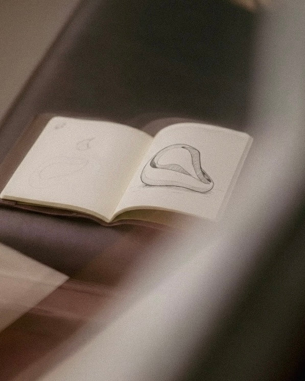 Open notebook with a drawing of a mouth on a dark surface