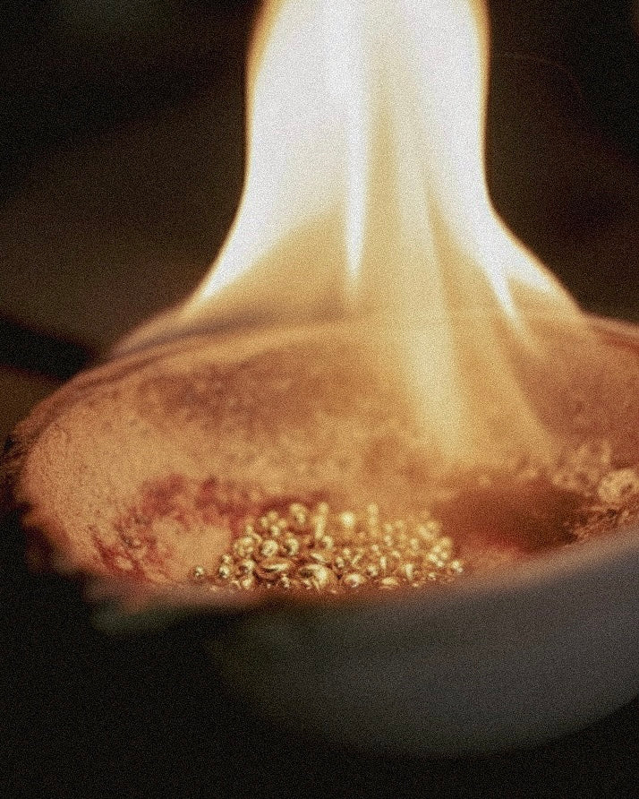 Close-up of a nose with gold jewelry on a dark background