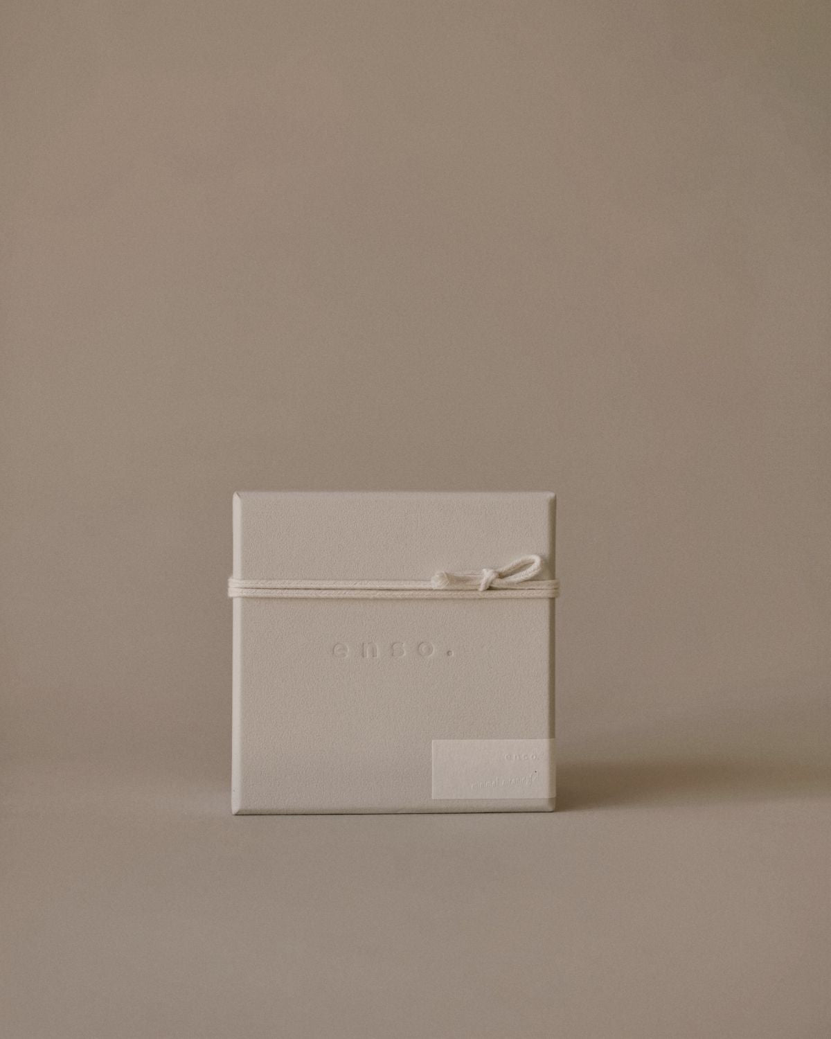 Close-up of Enso Design Lab™ packaging with embossed logo and smooth textured surface.