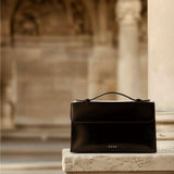 Essence Bag by Enso Design Lab™ in black box leather, its minimal design guided by Ani Han, evoking the quiet refinement of Hermès-like silhouettes.