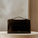 Essence Bag by Enso Design Lab™ in black box leather, its minimal design guided by Ani Han, evoking the quiet refinement of Hermès-like silhouettes.