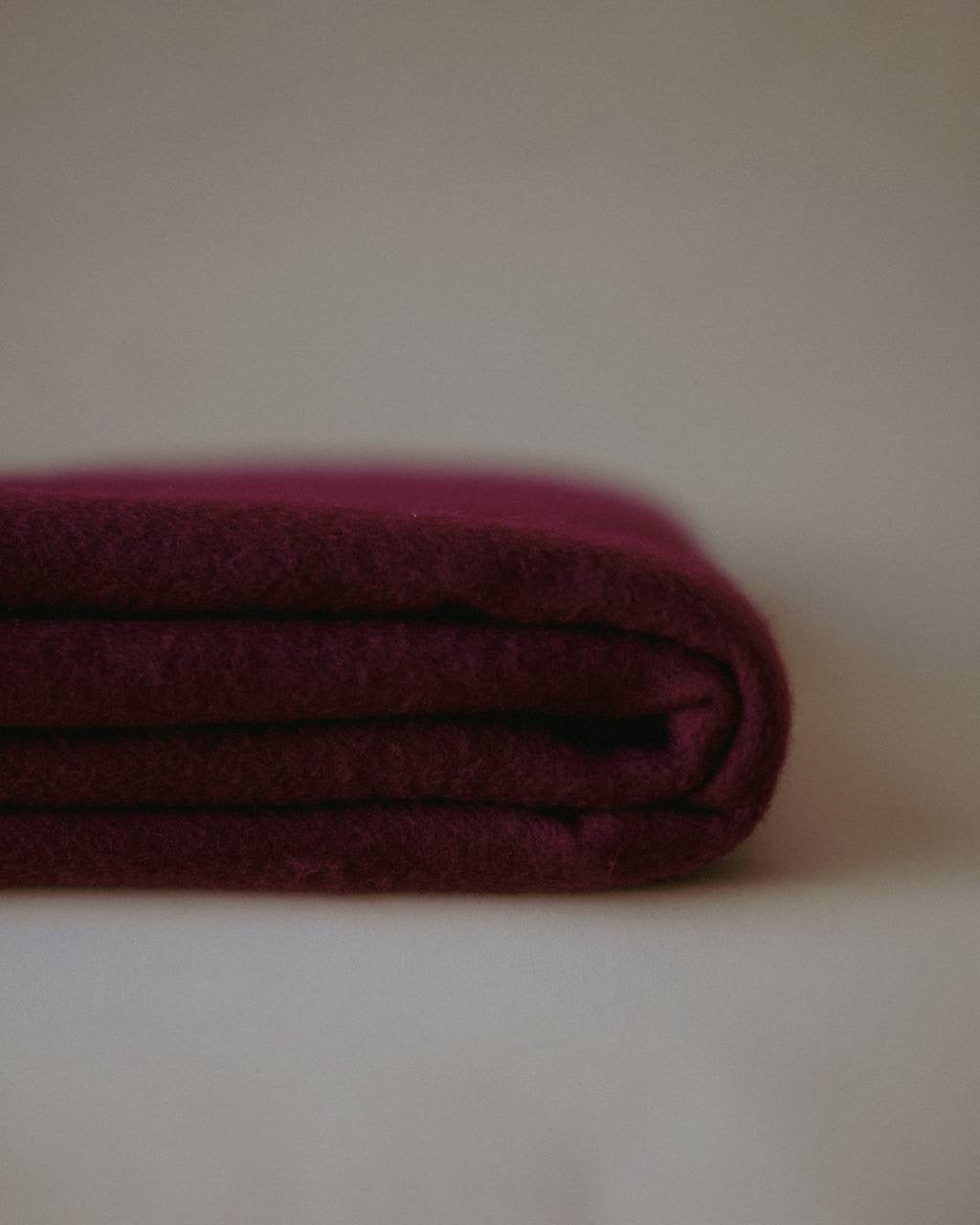 Stacked image of a burgundy cashmere scarf by Enso Design Lab™, featuring soft, premium fibers and refined detailing.