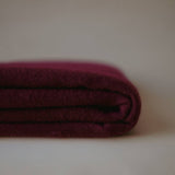 Stacked image of a burgundy cashmere scarf by Enso Design Lab™, featuring soft, premium fibers and refined detailing.