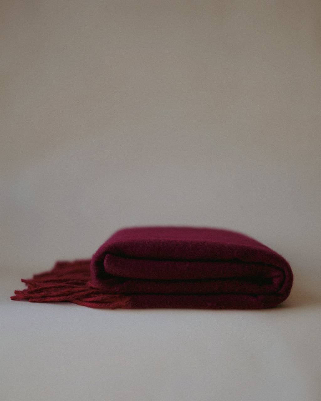 Luxurious cashmere scarf by Enso Design Lab™, crafted under the vision of Creative Director Ani Han, in a deep burgundy shade with soft fringes.