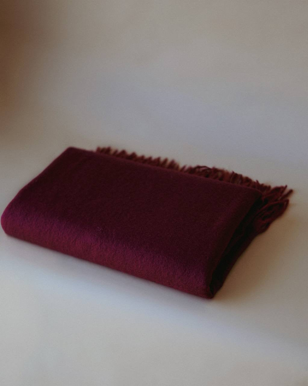 Folded burgundy cashmere scarf by Enso Design Lab™, blending timeless elegance with modern design.