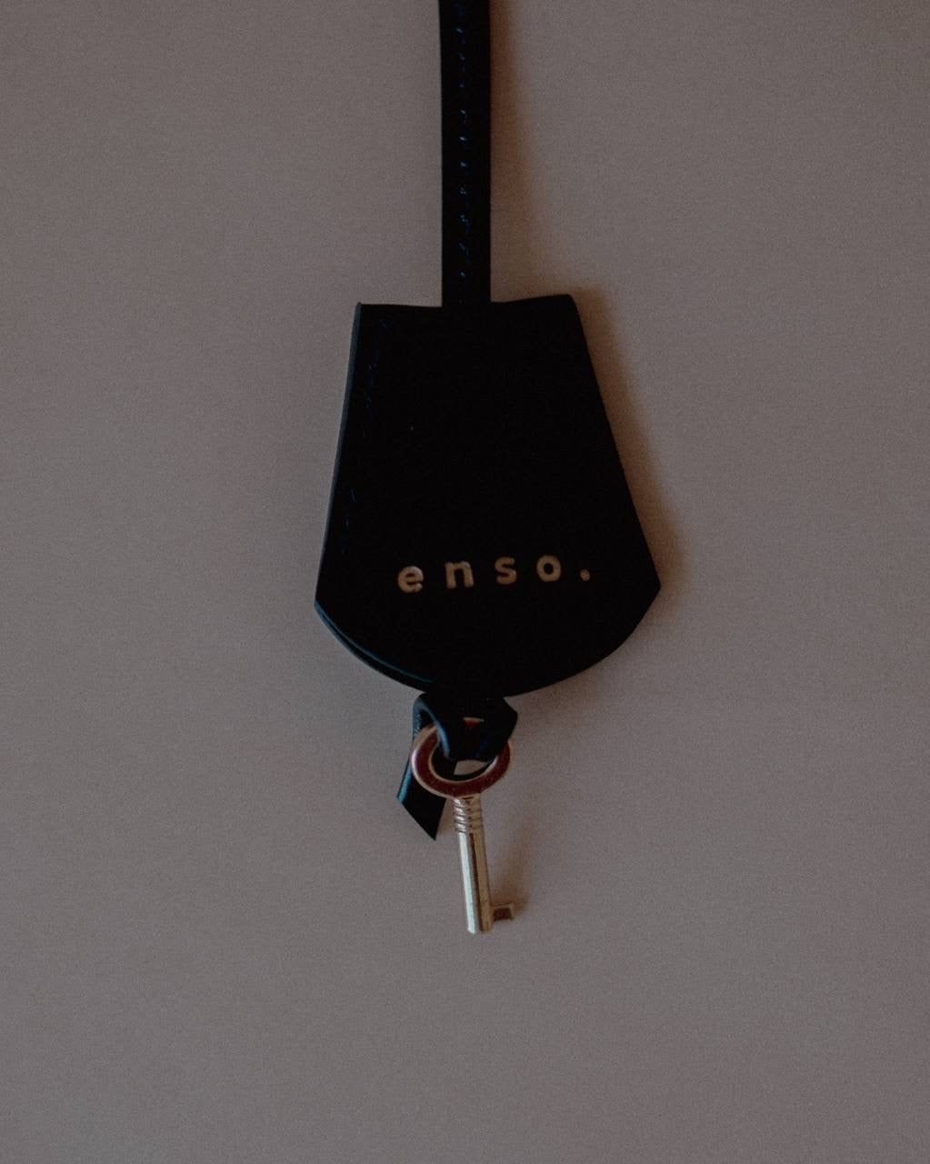 Leather Key Charm with Decorative Padlock, displayed with its leather strap, crafted from supple Noir Swift Leather.