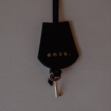 Leather Key Charm with Decorative Padlock, displayed with its leather strap, crafted from supple Noir Swift Leather.