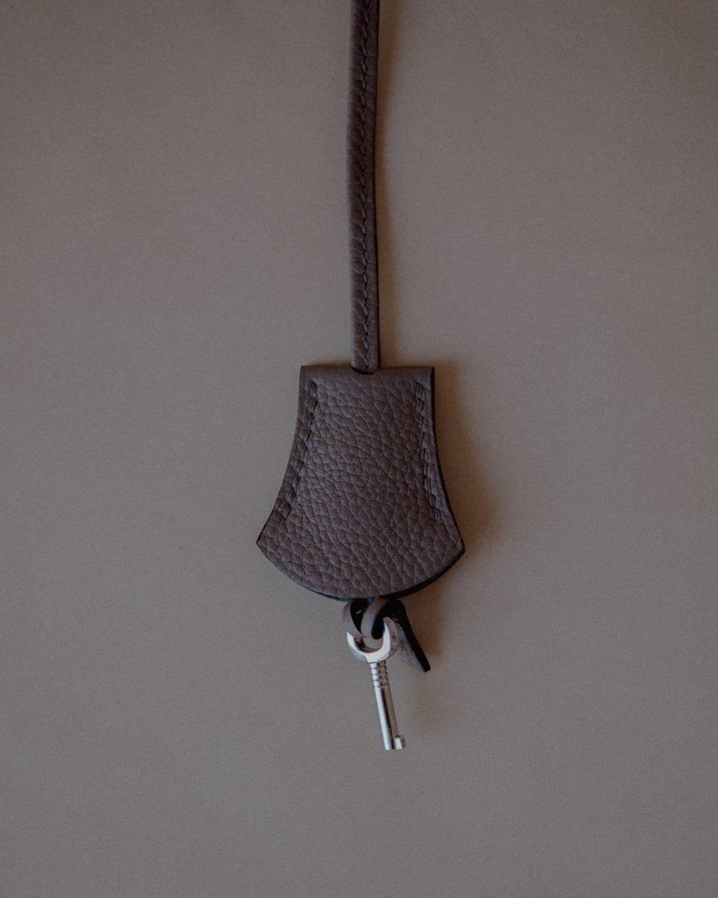 Top view of the Grey Leather Key Charm by Enso Design Lab™, emphasizing its seamless stitching and refined materials.