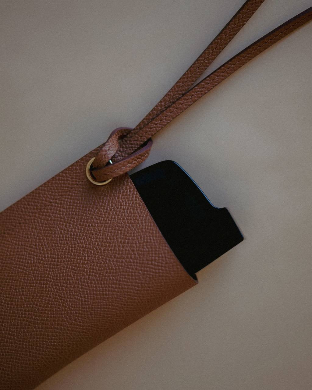 Side view of the Golden Brown Leather Sunglasses Holder, showcasing its pebbled leather texture and minimalist design.