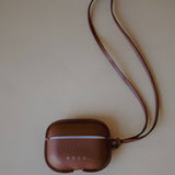 Front view of the Leather AirPods Case Necklace in Golden Brown Swift Leather by Enso Design Lab™, designed under the creative vision of Ani Han.