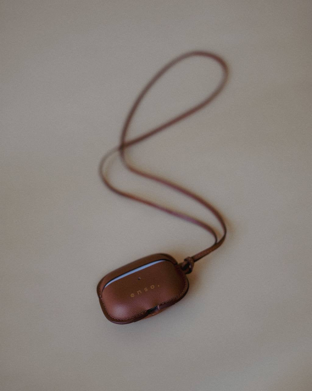 Leather AirPods Case Necklace with adjustable strap, showcasing the minimalist aesthetic of Enso Design Lab™ under Ani Han’s direction.