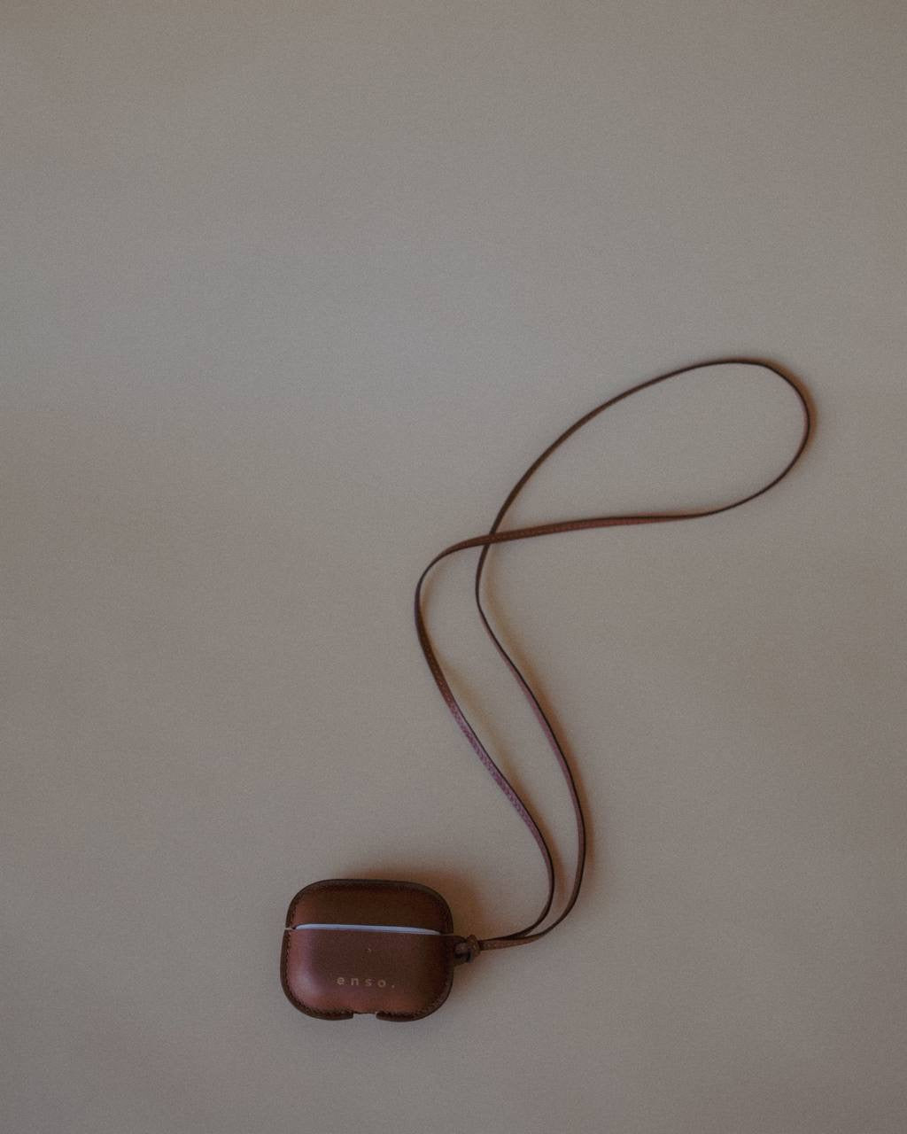 Leather AirPods Case Necklace with adjustable strap, showcasing the minimalist aesthetic of Enso Design Lab™ under Ani Han’s direction.