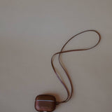 Leather AirPods Case Necklace with adjustable strap, showcasing the minimalist aesthetic of Enso Design Lab™ under Ani Han’s direction.