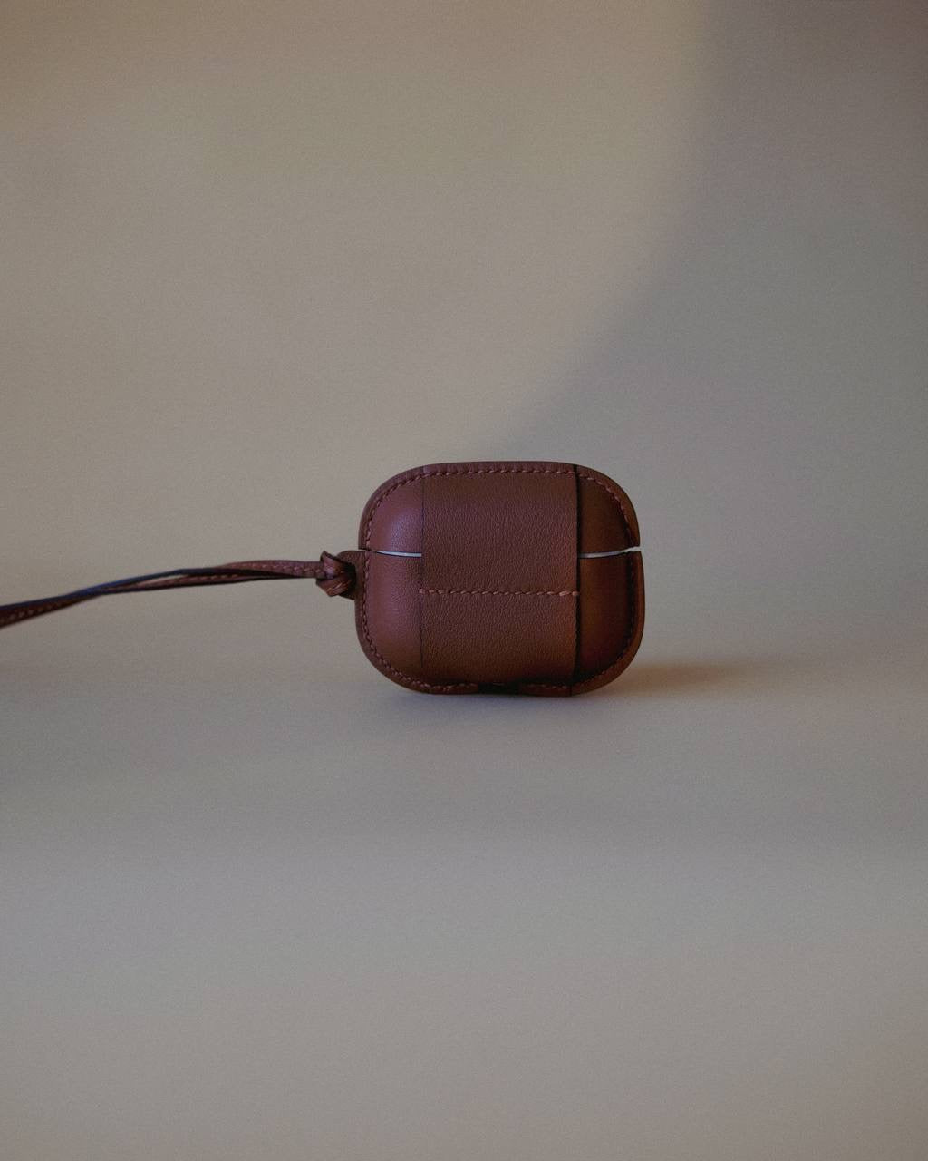 Leather AirPods Case Necklace with adjustable strap, showcasing the minimalist aesthetic of Enso Design Lab™ under Ani Han’s direction.