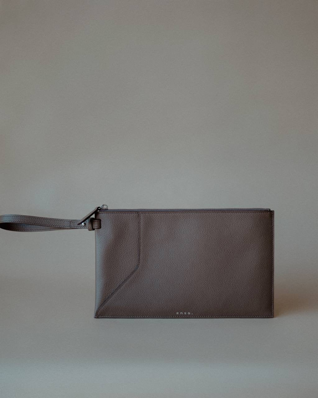 Side view of the Grey Wristlet Pouch, showcasing its premium pebbled leather and refined stitching.