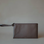 Side view of the Grey Wristlet Pouch, showcasing its premium pebbled leather and refined stitching.