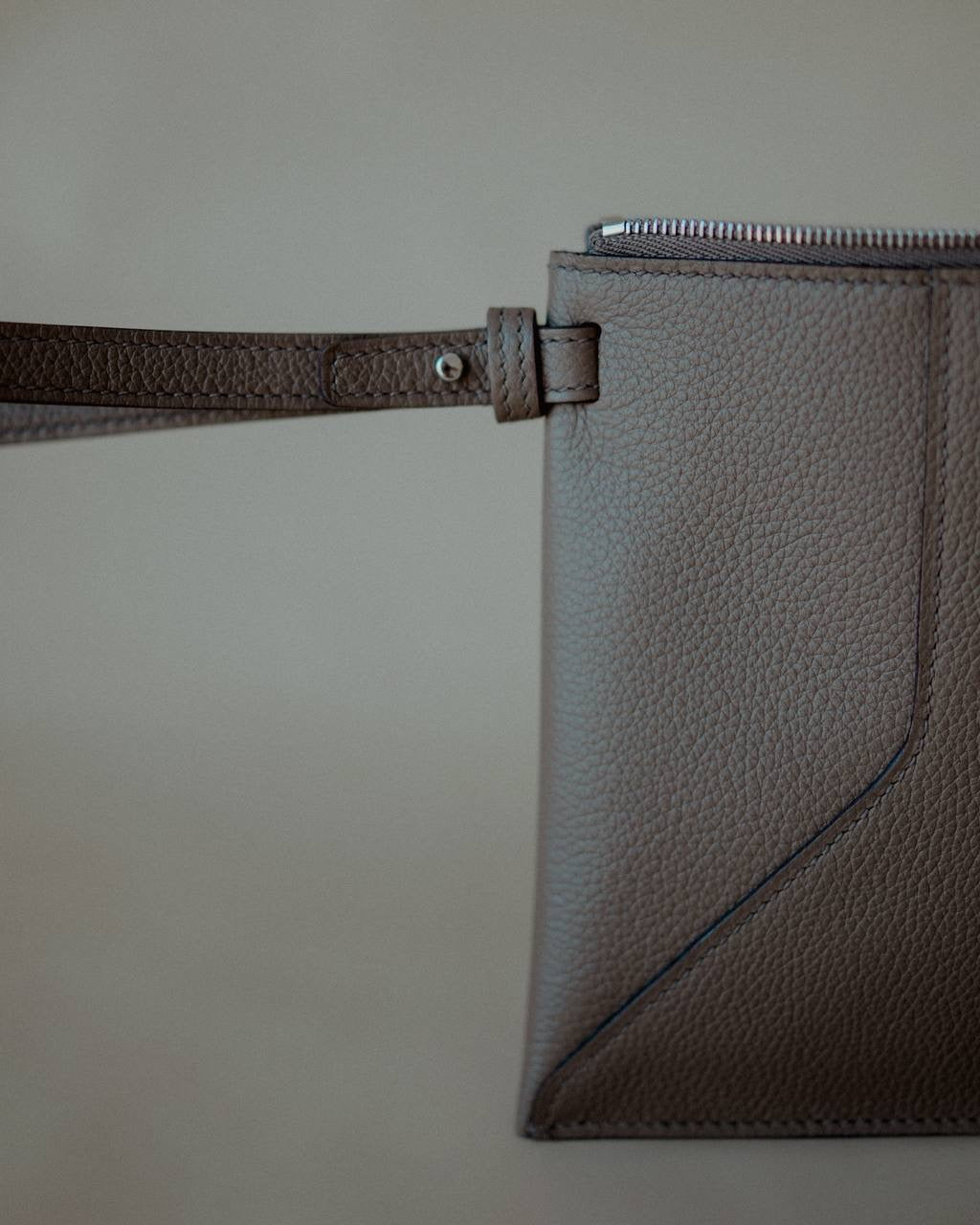 Close-up of the detachable wrist strap, highlighting the pouch’s elegant and functional design.