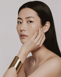 Model wearing Shell Cuff gold-plated brass bracelet on wrist