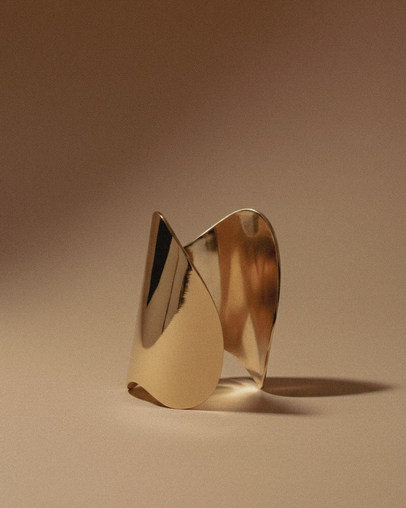 Shell Cuff gold-plated bracelet on a beige background